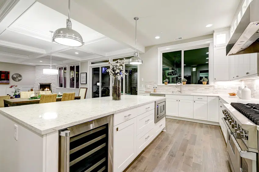 kitchen with white cabinets marble countertops stone subway tile backsplash and gorgeous kitchen island