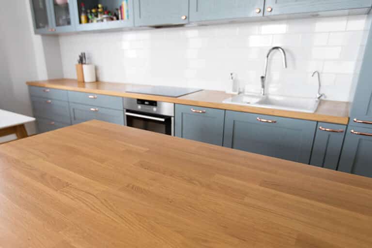 Are Wood Countertops Worth It Explore Their Pros And Cons   Kitchen With Wood Countertops Light Gray Blue Cabinets White Tile Backsplash Ss 768x512 