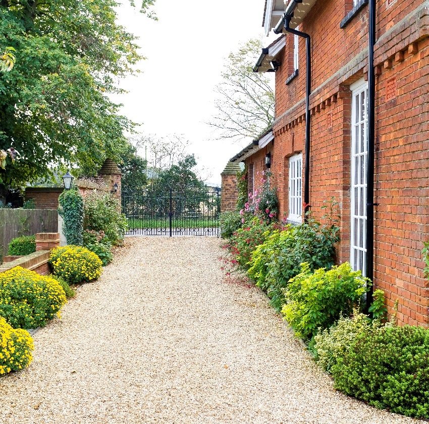 country mansion house with wrought iron gates and gravel drive