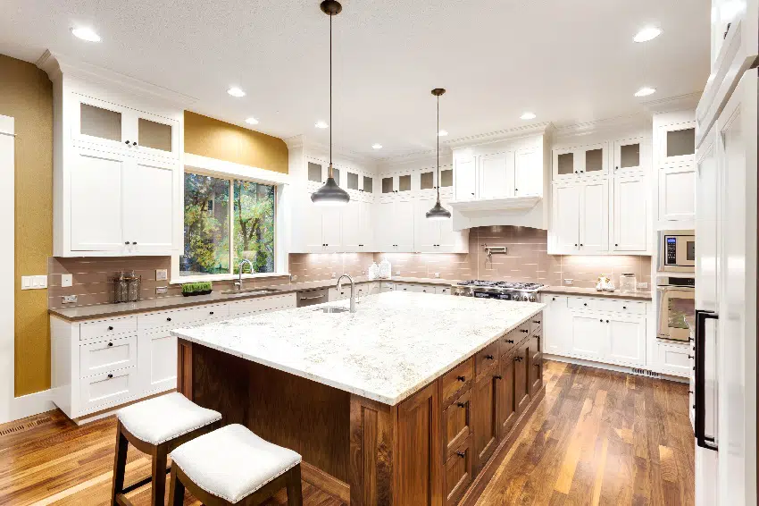 large kitchen interior with wooden island sink white cabinets pendant lights and hardwood floors