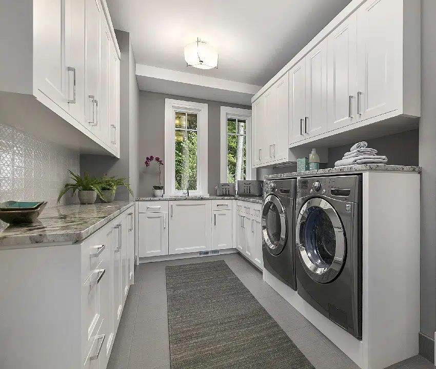 laundry room with gray wall paint and white storage cabinets