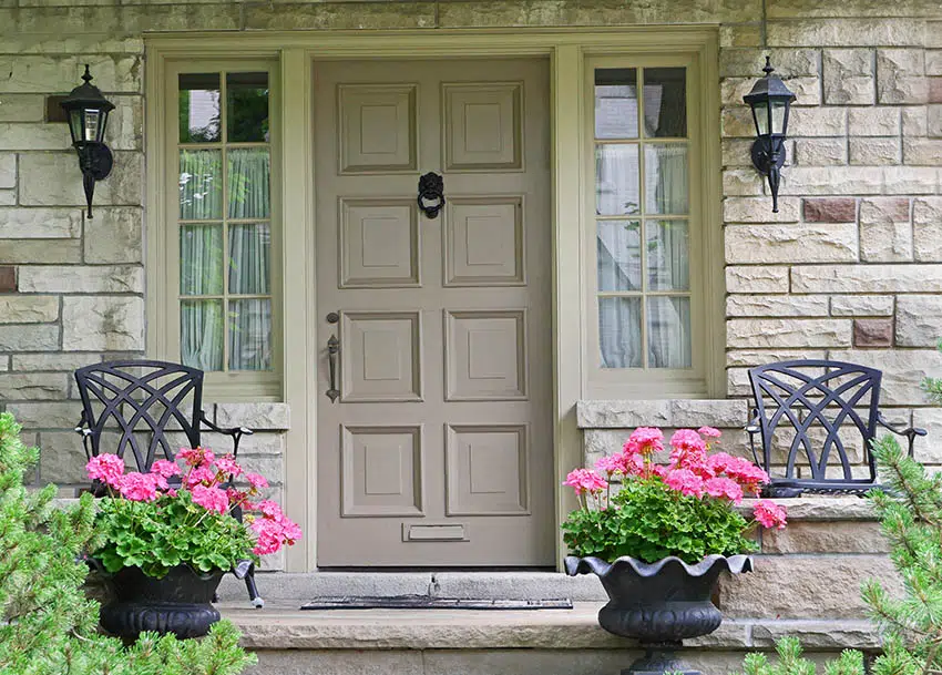 Light brown front door with outdoor chair and potted flowers