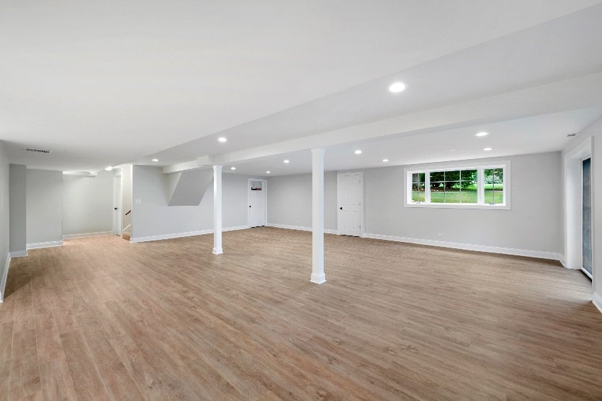 ight grey spacious basement area with wood flooring