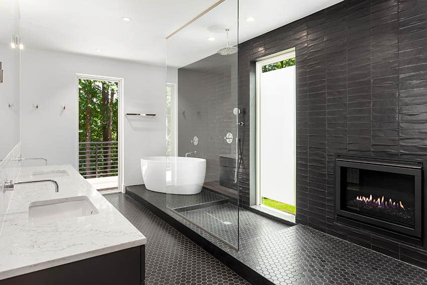 Luxury bathroom with black hexagon mosaic floor tile shower freestanding tub marble countertops gas fireplace