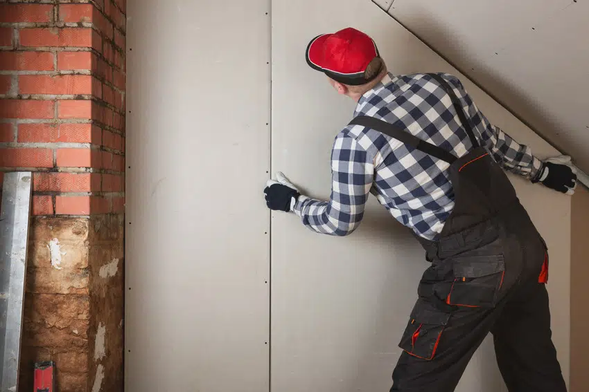 Man installing precast panel for basement construction