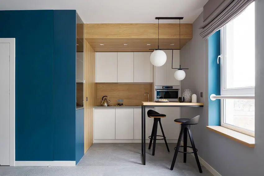 modern and small kitchen with console table two chairs wooden walls and gray floor tiles blue wall and window
