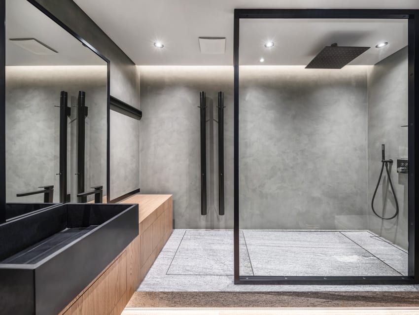 Modern bathroom with gray cultured marble walk in shower and wood bench