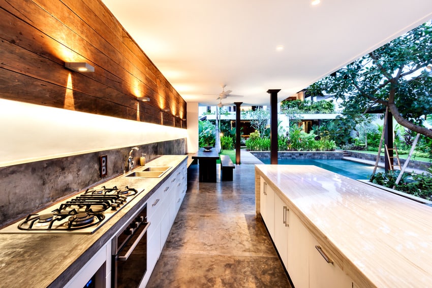 Covered patio area with cooktop and sconce lighting