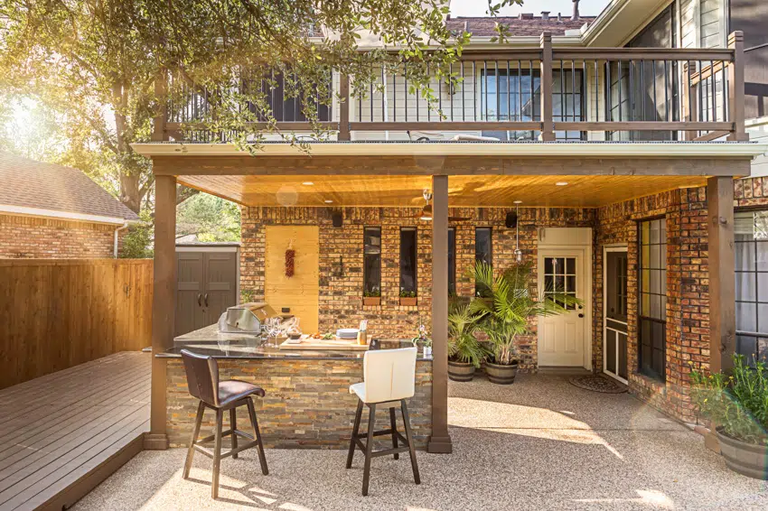 Modern outdoor kitchen with island stools grill in patio