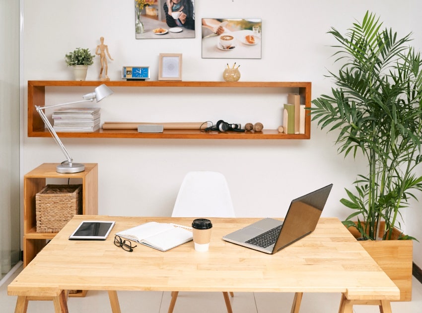 opened laptop digital tablet planner and cup of coffee on table in modern office