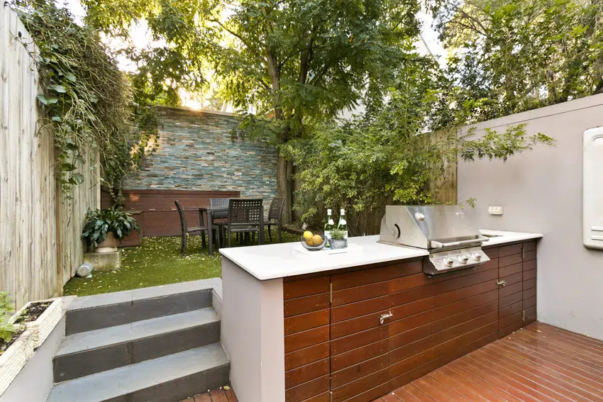 Outdoor kitchen with grill in backyard dining area