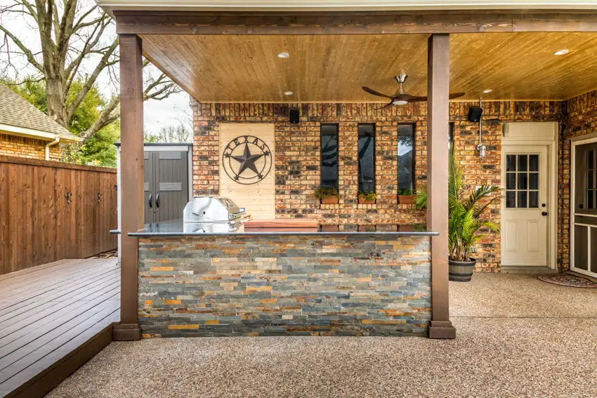 Outdoor patio with grill countertop and brick wall
