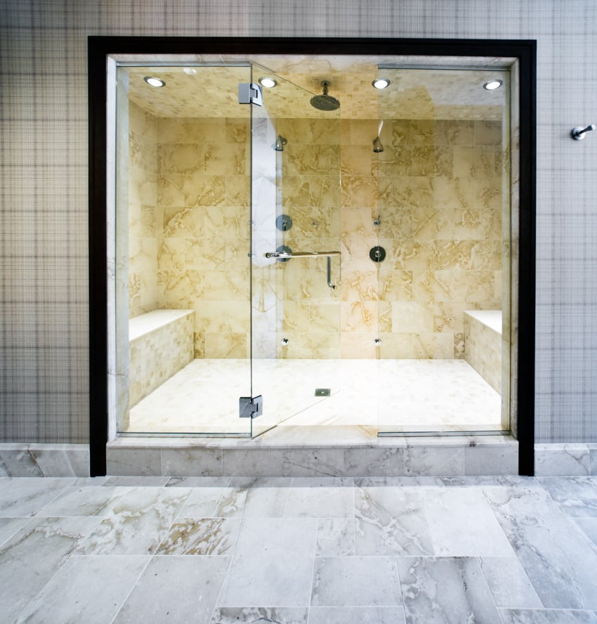 Pair of marble built in shower benches and a glass door