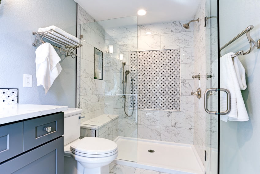 Shower bench in tiled bathroom with toilet and cabinet