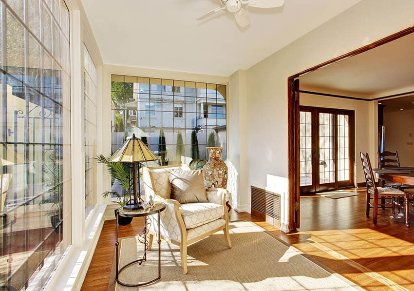 Small sunroom with white ceiling cream painted walls light color flooring