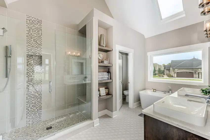 Spacious bathroom with shower area bench sink toilet and shelves