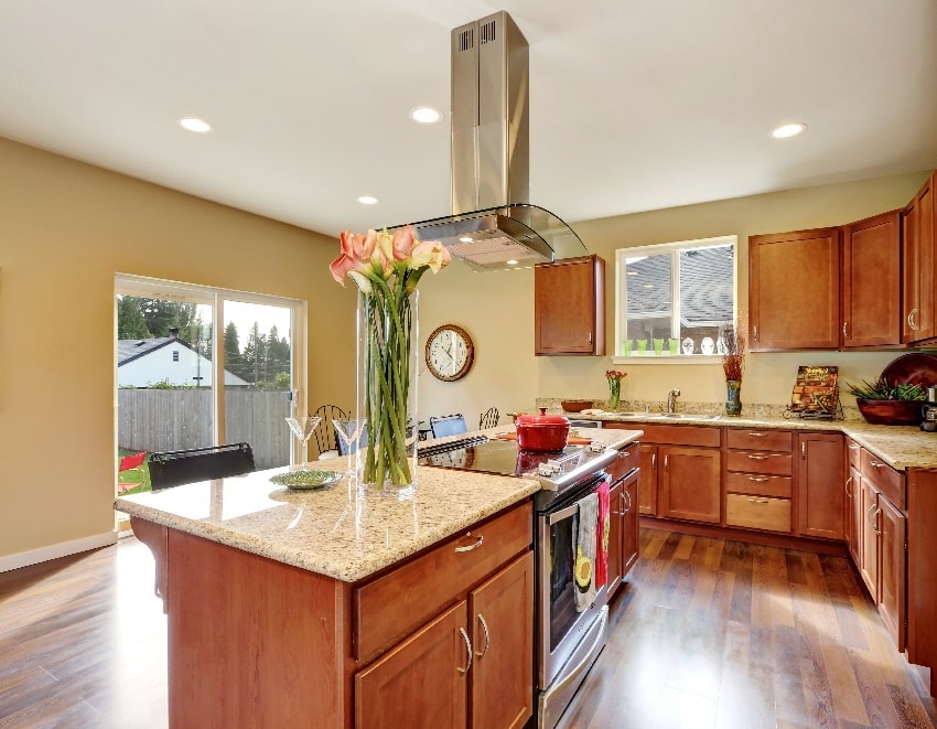 traditional american kitchen with warm beige wall paint stainless steel appliances and vase with flowers on the island countertop