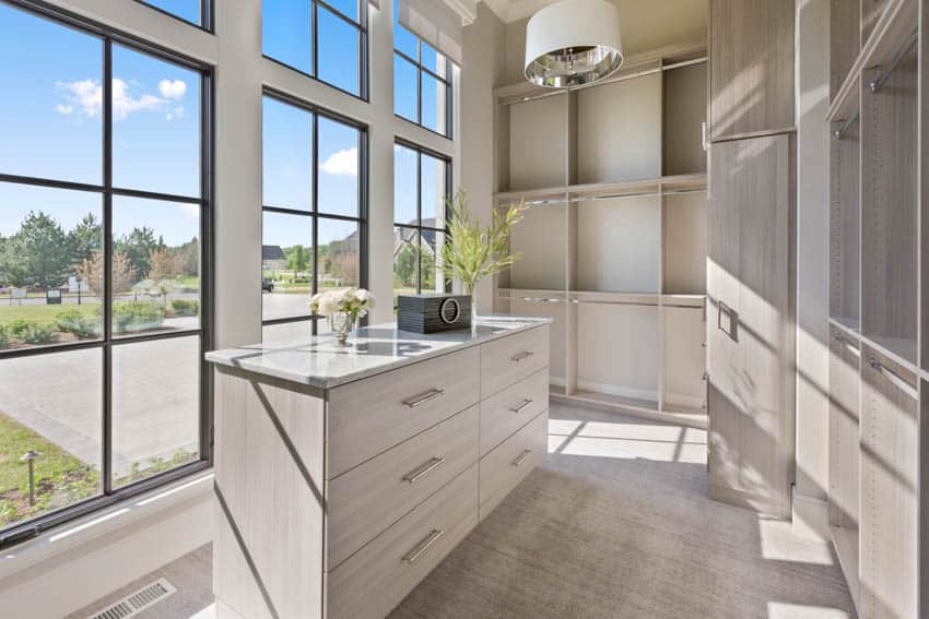 Closet with window views and beige flooring