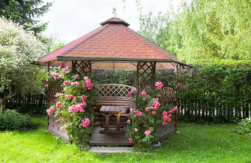 Wood gazebo with pink roses wood table bench