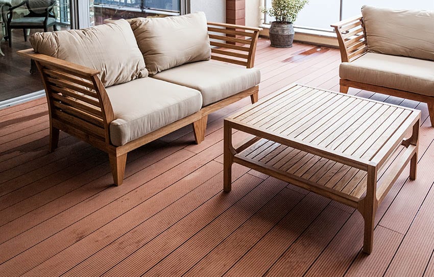 Wood outdoor sofa and chairs with cushions on deck