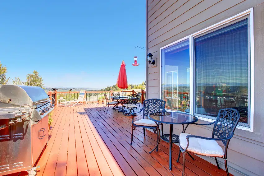 wooden walkout ipe deck with patio table and barbecue overlooking beautiful landscape