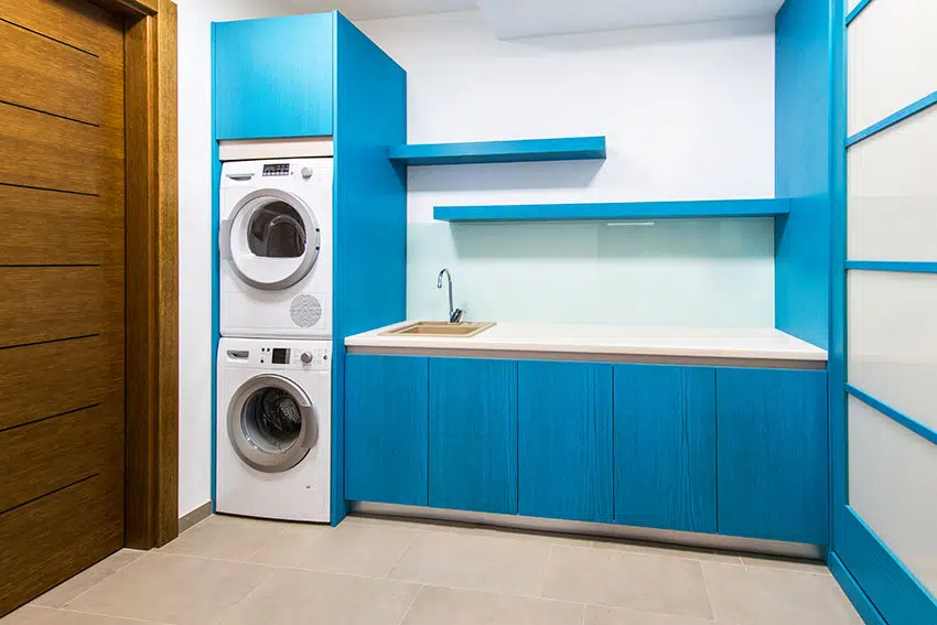 Laundry room with stacked washers blue cabinets is
