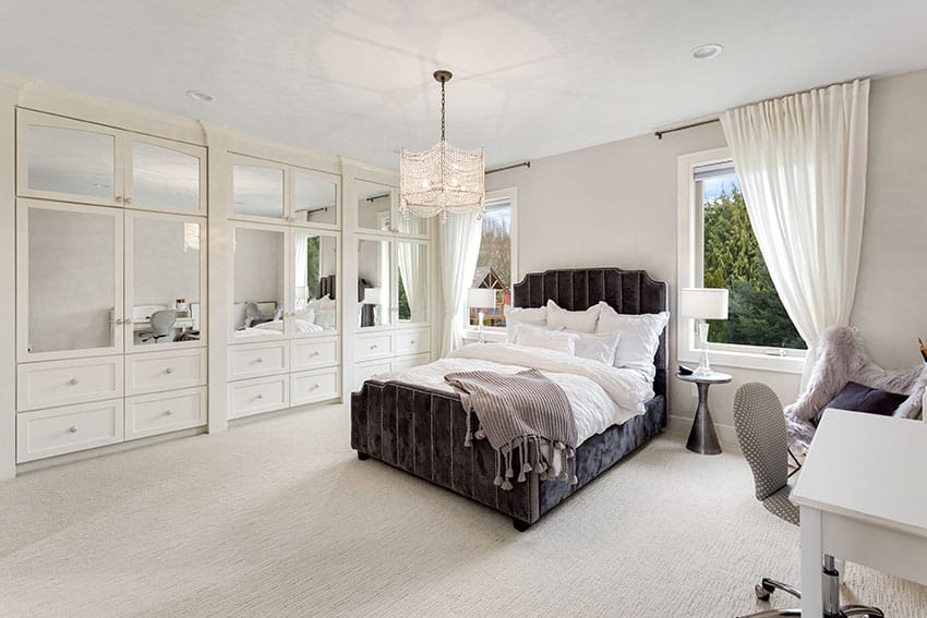 Master bedroom with built in wardrobe cabinets with drawers pendant light