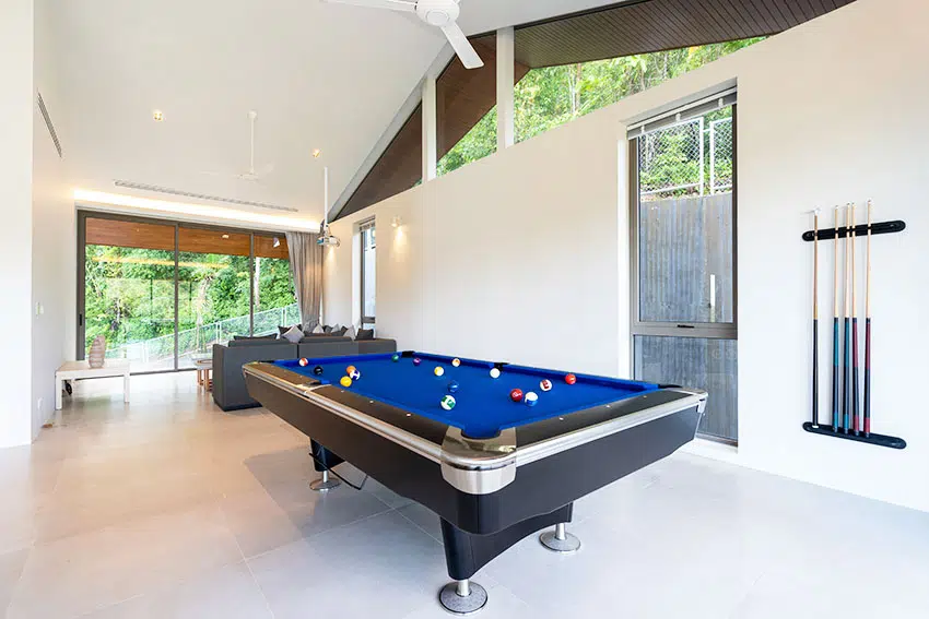 Game room with pool table white paint glass windows ceiling fans