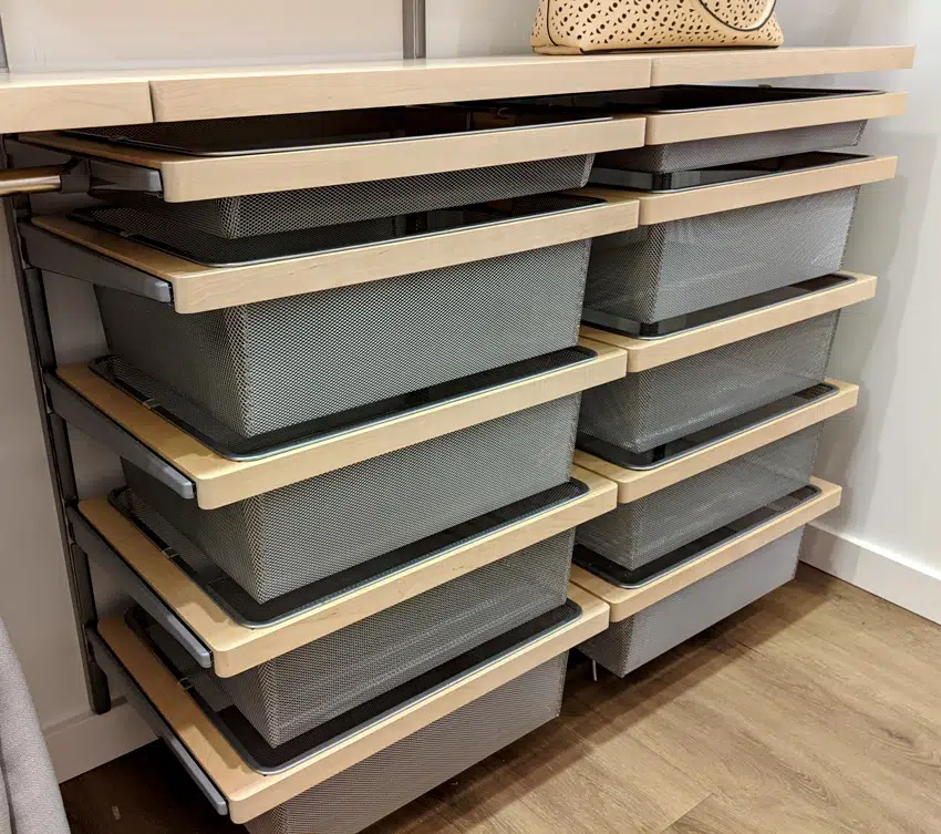 A set of wire mesh drawers inside a large walk in closet