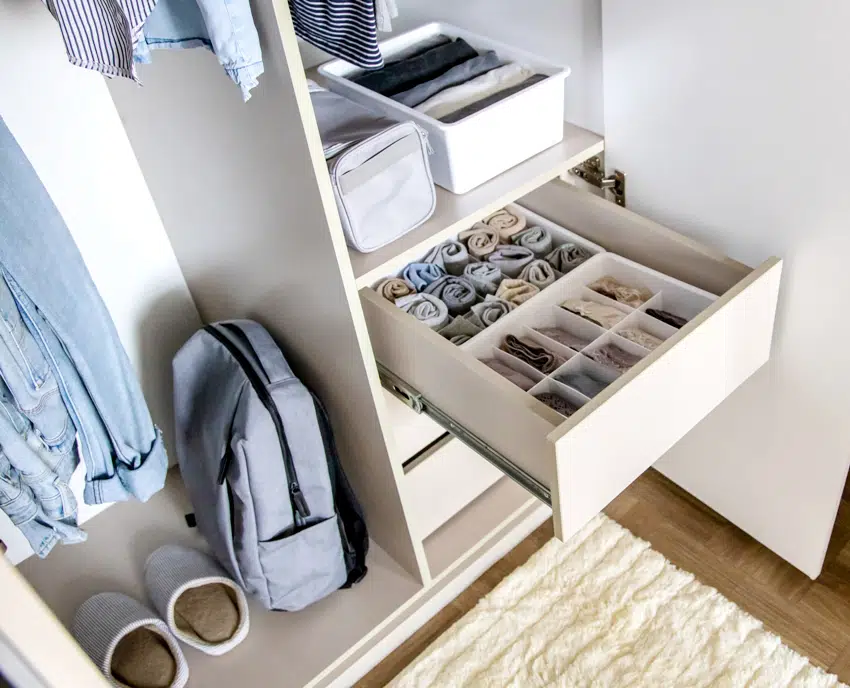 A very well organized wardrobe with clothes rolled and placed in boxes separately