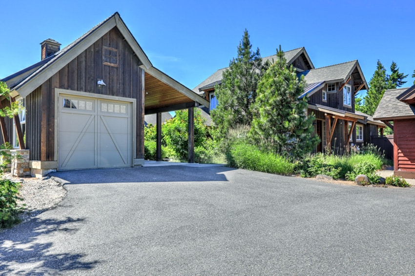 Asphalt millings driveway leading to garage and house