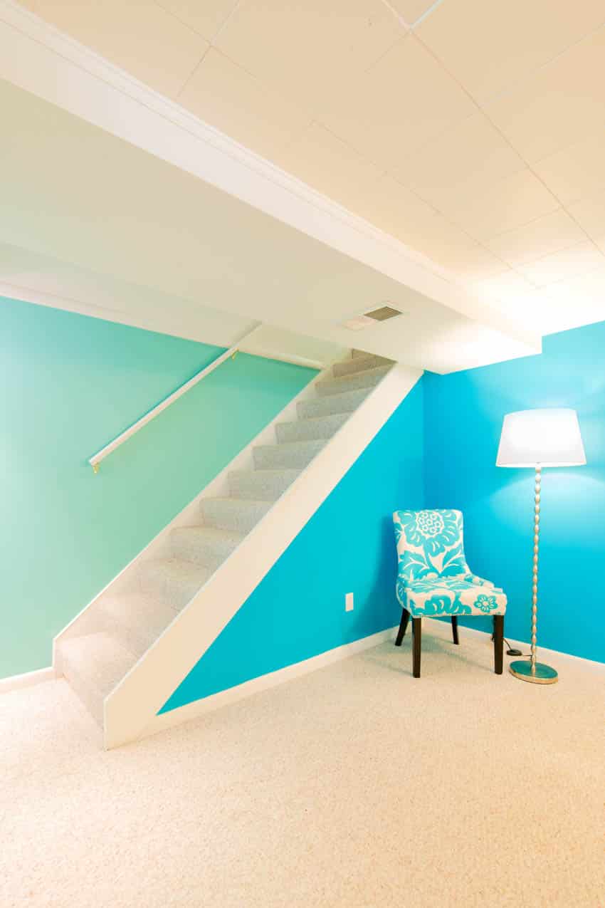 Basement blue wall white ceiling chair lamp stairs