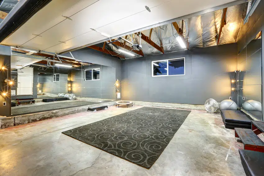 Basement with poured concrete wall mirrors and carpet