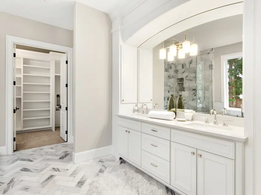 bathroom interior with beautiful circular mirror and hardwood vanity