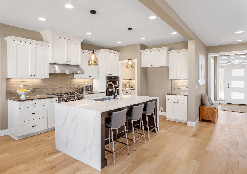 beautiful kitchen with island pendant lights and wood laminated floors