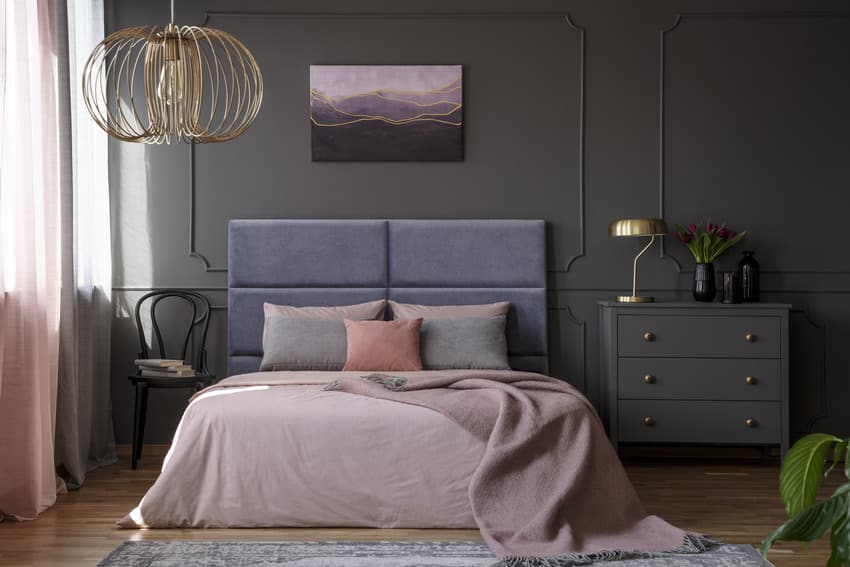 Bedroom with stylish light fixture poster frame and wooden flooring