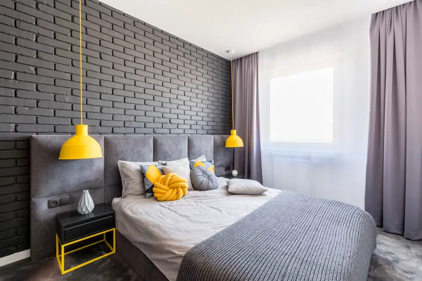 Bedroom with gray brick pattern wall curtains and yellow hanging light