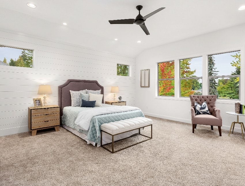 bedroom with large windows ceiling fan carpet and white wall