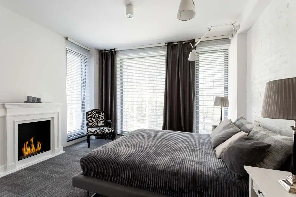 bedroom with gray bedding and fireplace