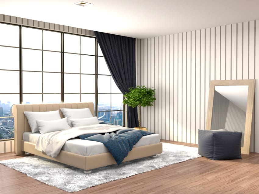 beige bedroom interior with black curtains mirror beige bed gray carpet and wooden floors