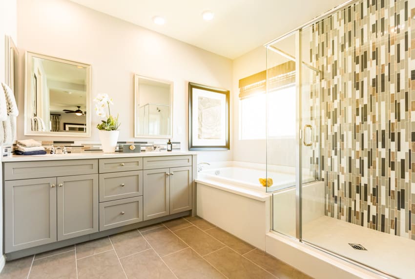 Bright bathroom with wall tile pattern cabinets sink and shower pan