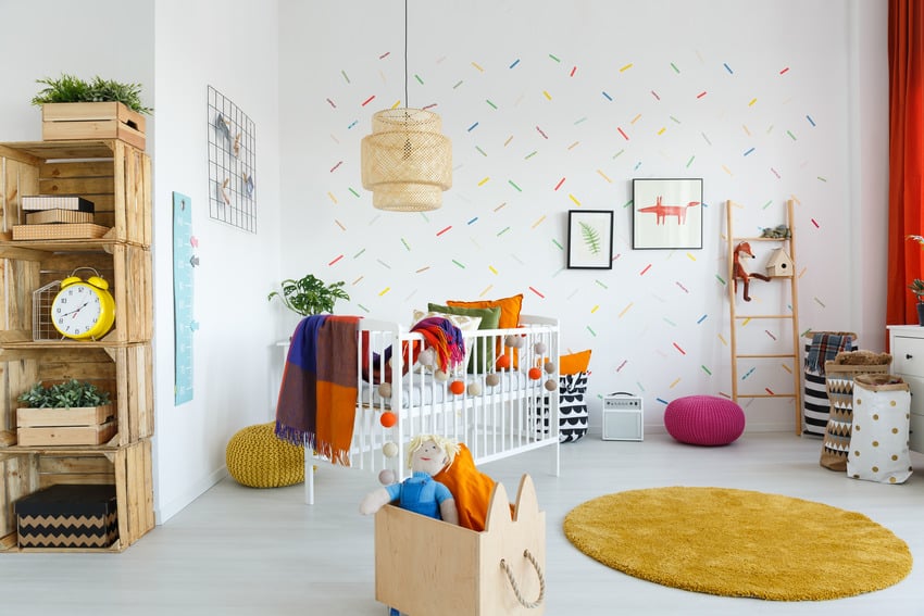 Contemporary baby room design with stylish lighting fixture and vibrant dyed rug