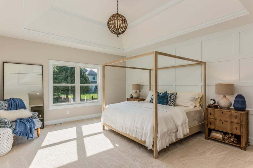 Contemporary bedroom with stylish light fixture wooden bed frame and neutral carpet