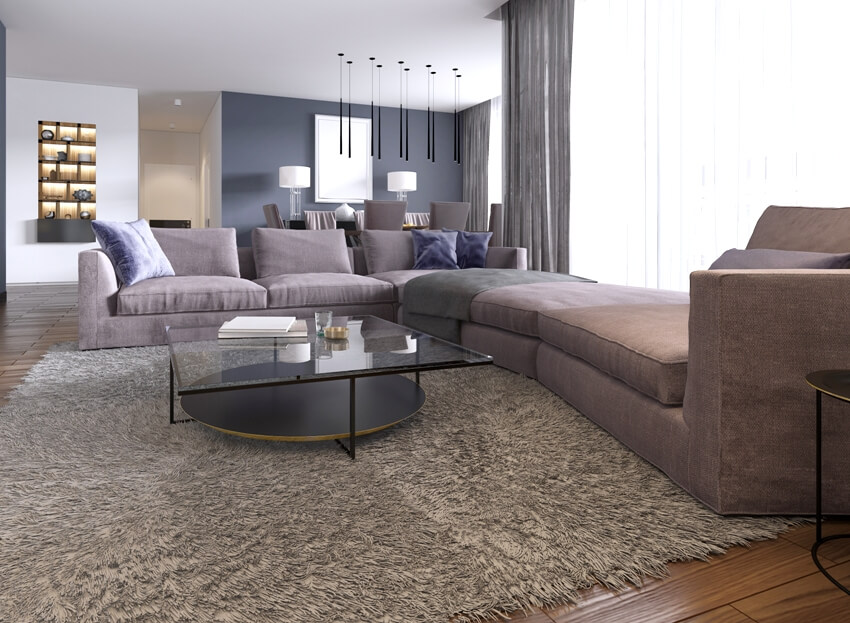 Contemporary large living room with a large sofa brown carpet and dining area