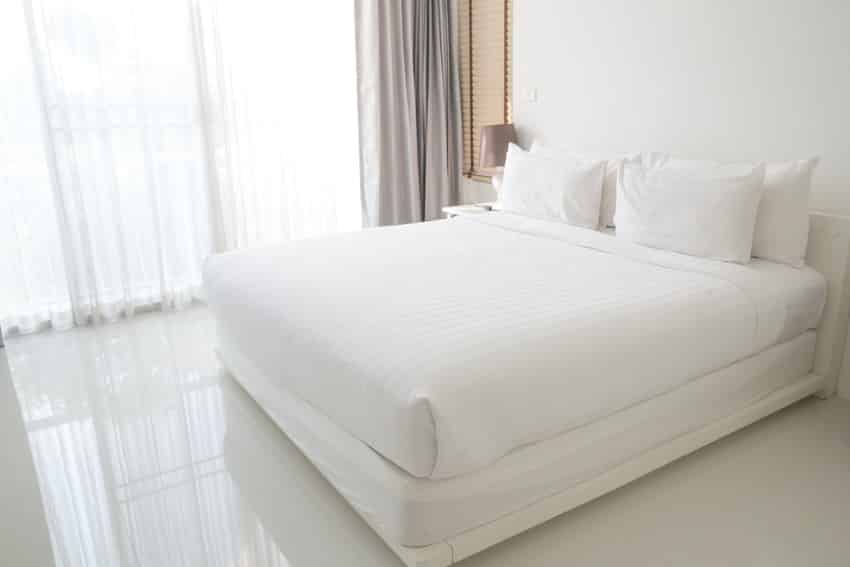 Cotton bed sheet in classic white bedroom interior