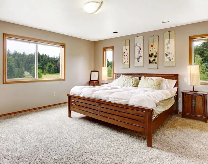 Cozy bedroom interior with double wooden bed and beige carpet floor