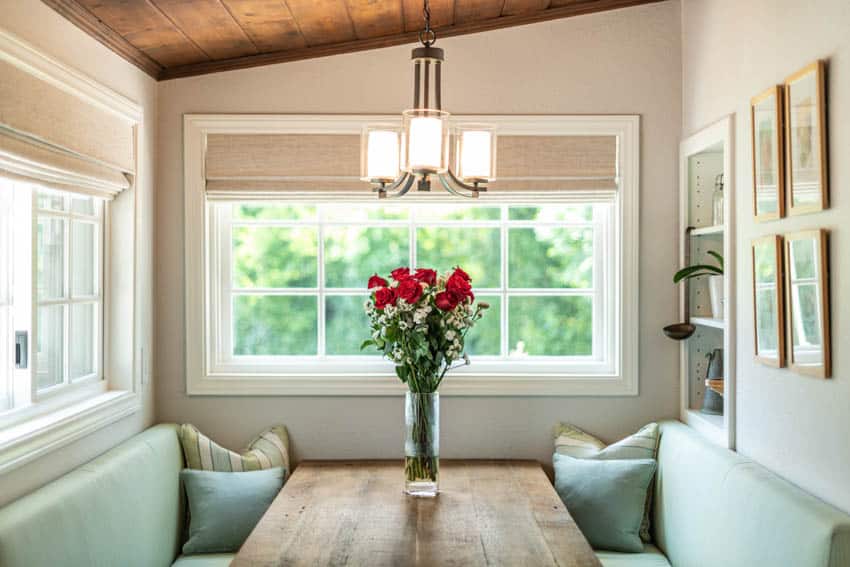 Cozy booth for eating with pillows flower vase and hanging light