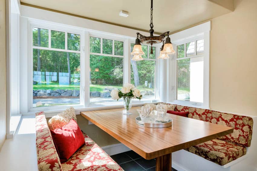 Cozy dining nook wood table white windows hanging light