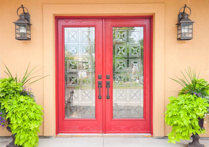 Crested glass on red door with potted plants