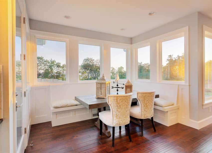 Dining area booth with wood floor and white chairs